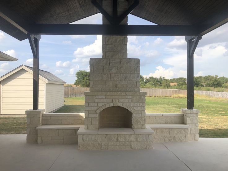 an outdoor fireplace in the middle of a patio