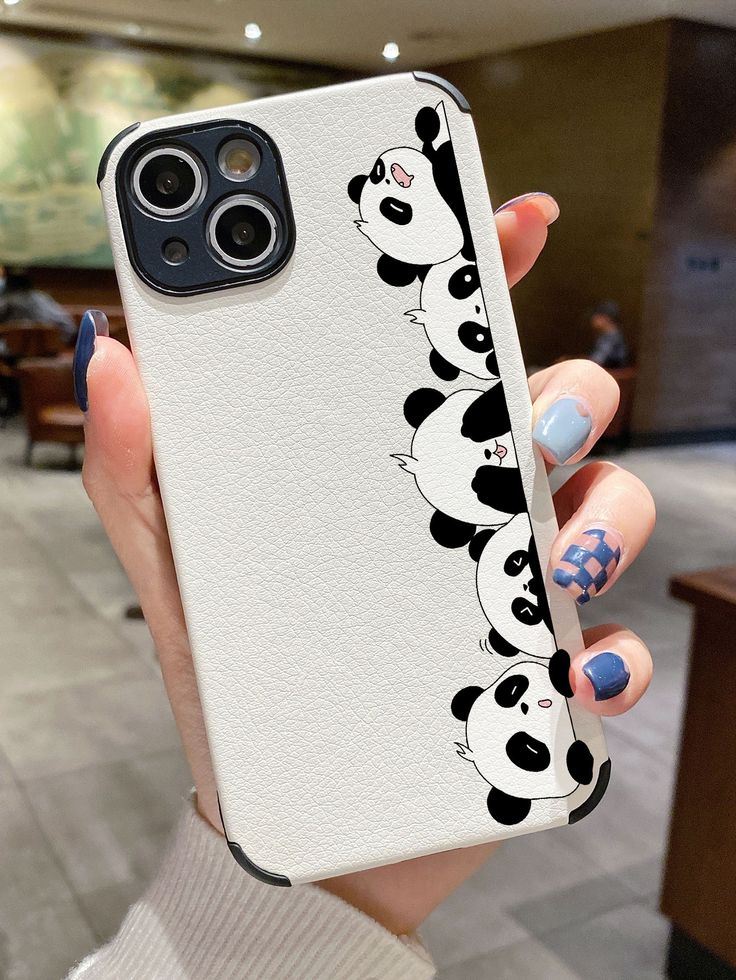 a woman holding up her phone case with pandas on it