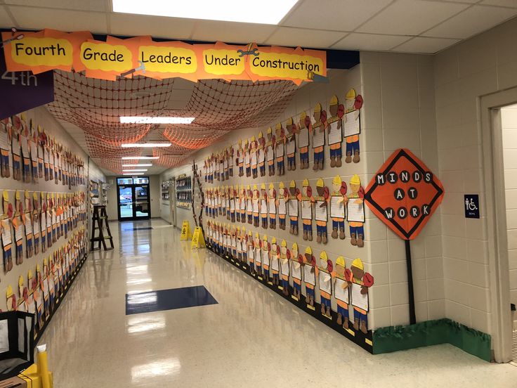 an empty hallway with posters on the wall and caution signs hanging from the ceiling in front of them