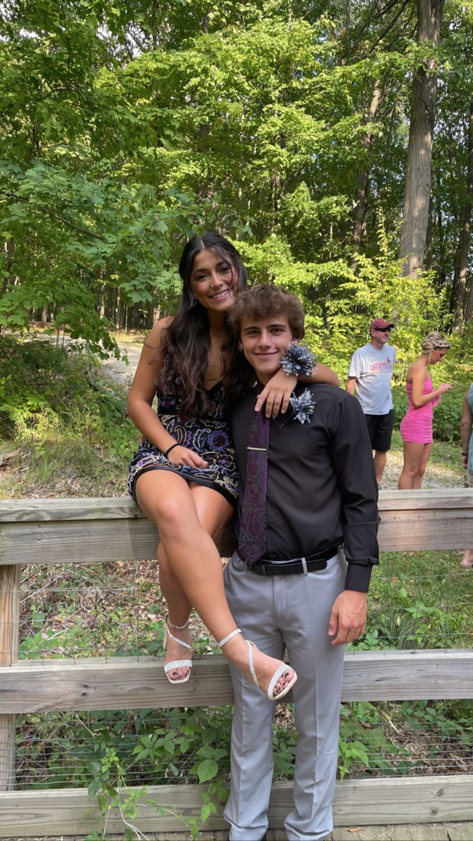 a man and woman posing on a wooden bench