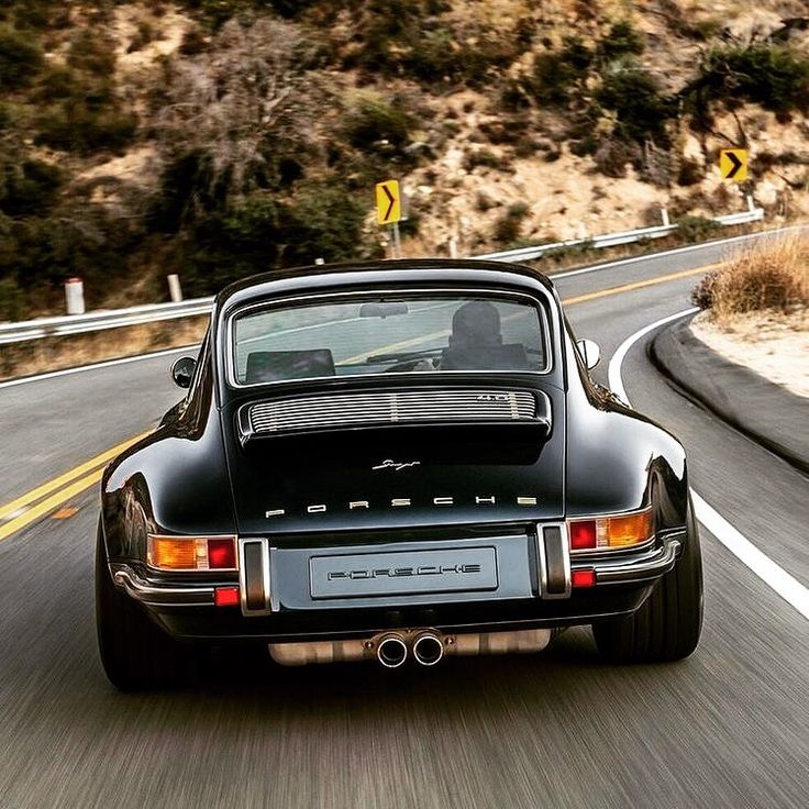 a black sports car driving down the road