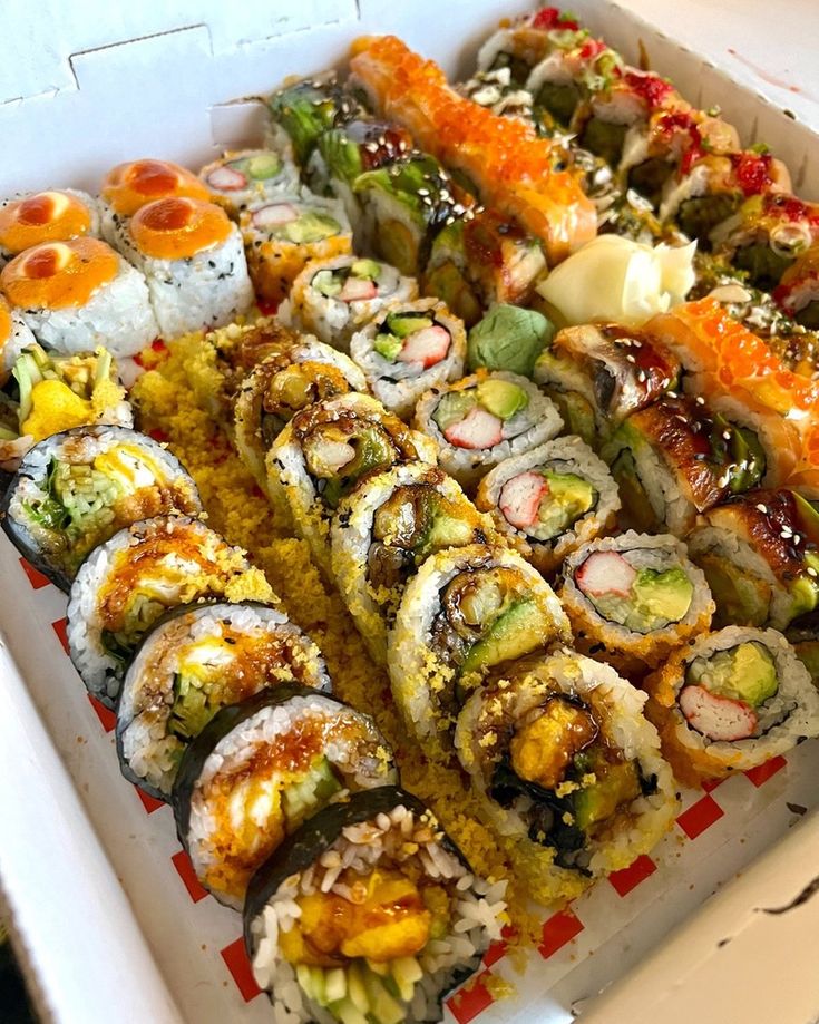 sushi platter with various types of sushi and other food items in it