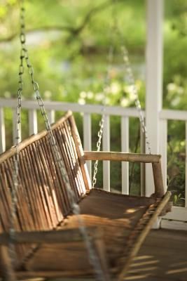 a wooden swing sitting on top of a porch