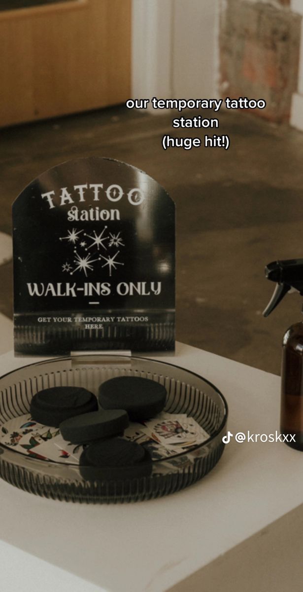 a tattoo parlor display with various products on the table and an advertise for it