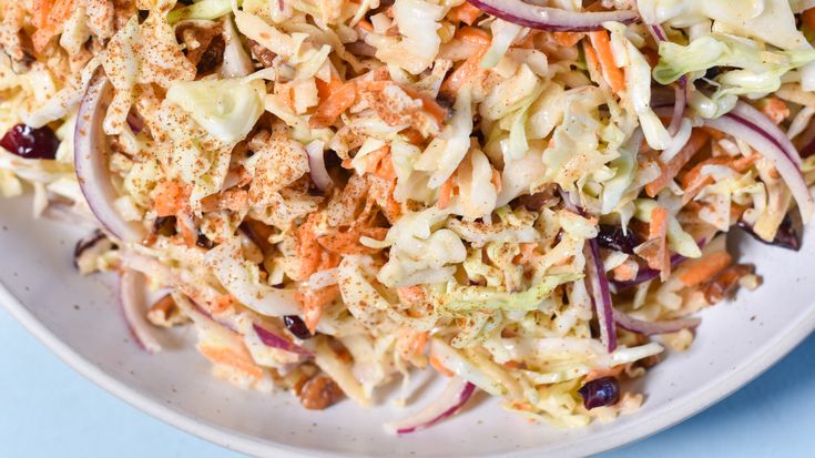 a white plate topped with coleslaw and carrots