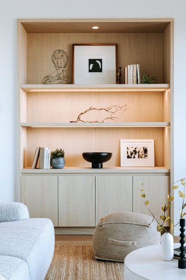 a living room filled with furniture and bookshelves next to a wall mounted shelf