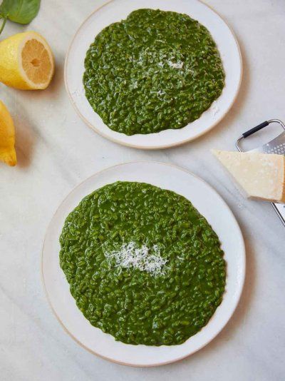 two white plates topped with green sauce next to sliced lemons