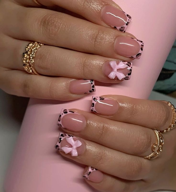 a woman's hands with pink and black nail polishes on her nails, holding a pink cup