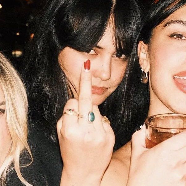 three women posing for the camera with their fingers up