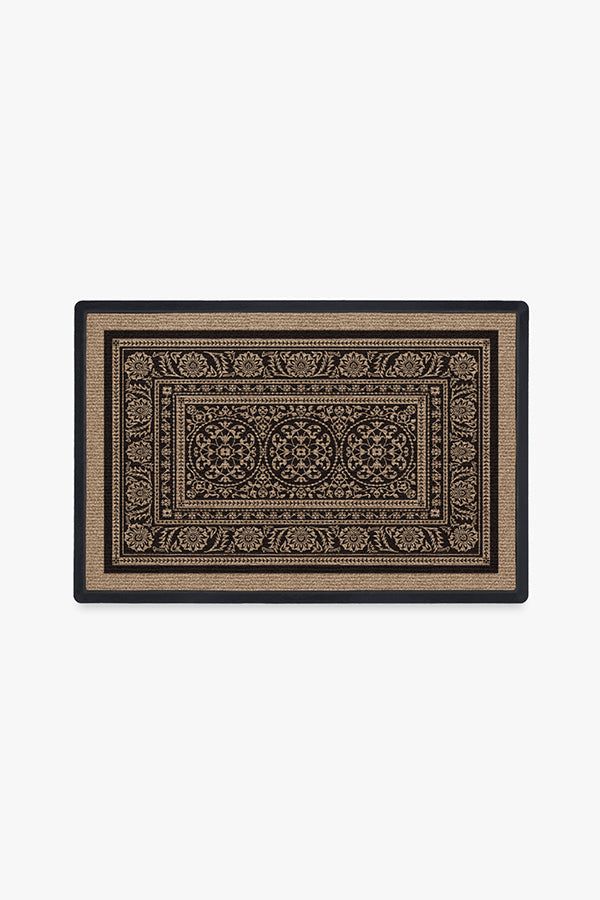 a black and tan rug with an intricate design on the bottom, in front of a white background