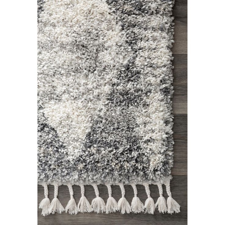 an area rug with fringes and tassels on the bottom, in grey tones