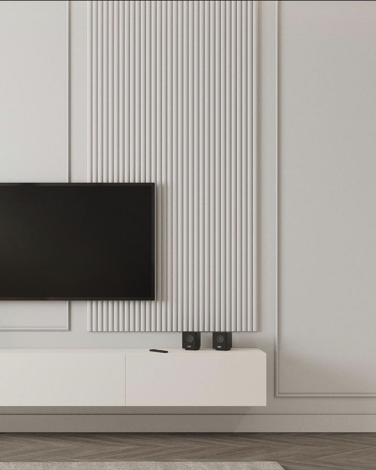 a flat screen tv mounted to the side of a white wall in a living room