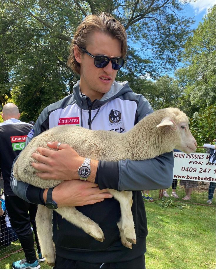 a man holding a sheep in his arms