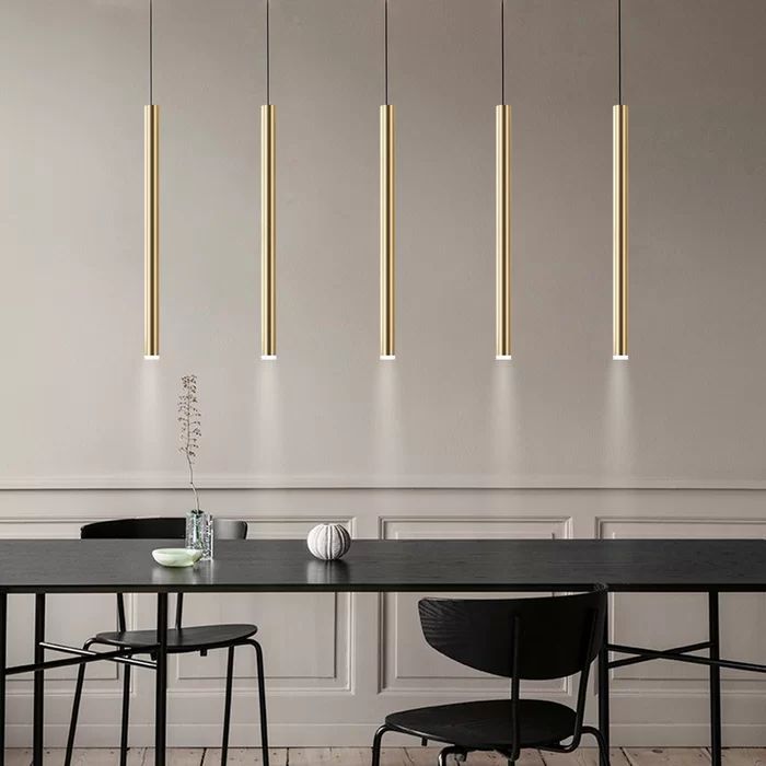 a dining room table with four lights hanging above it