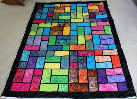 a multicolored quilt is laying on the floor