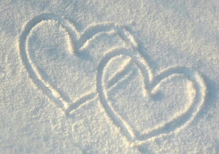 a heart drawn in the snow with an arrow