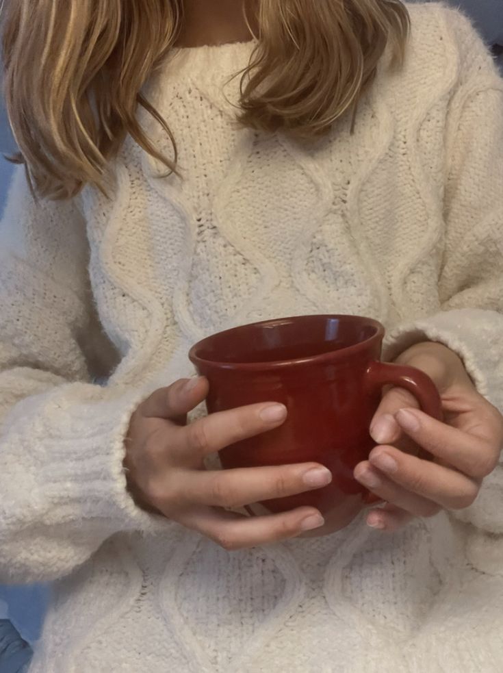 a woman holding a red cup in her hands