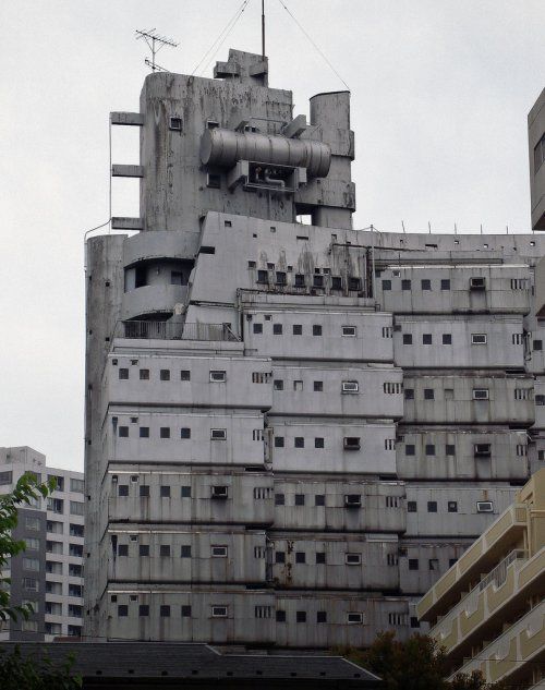 an old building with lots of windows and pipes on the top of it's roof