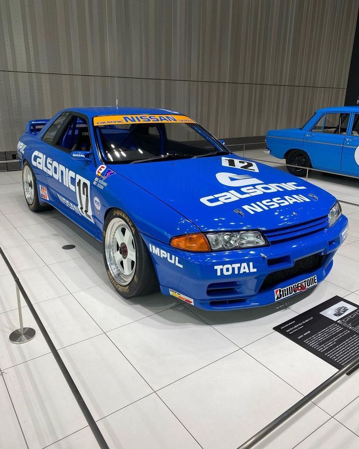 a blue car is on display in a museum