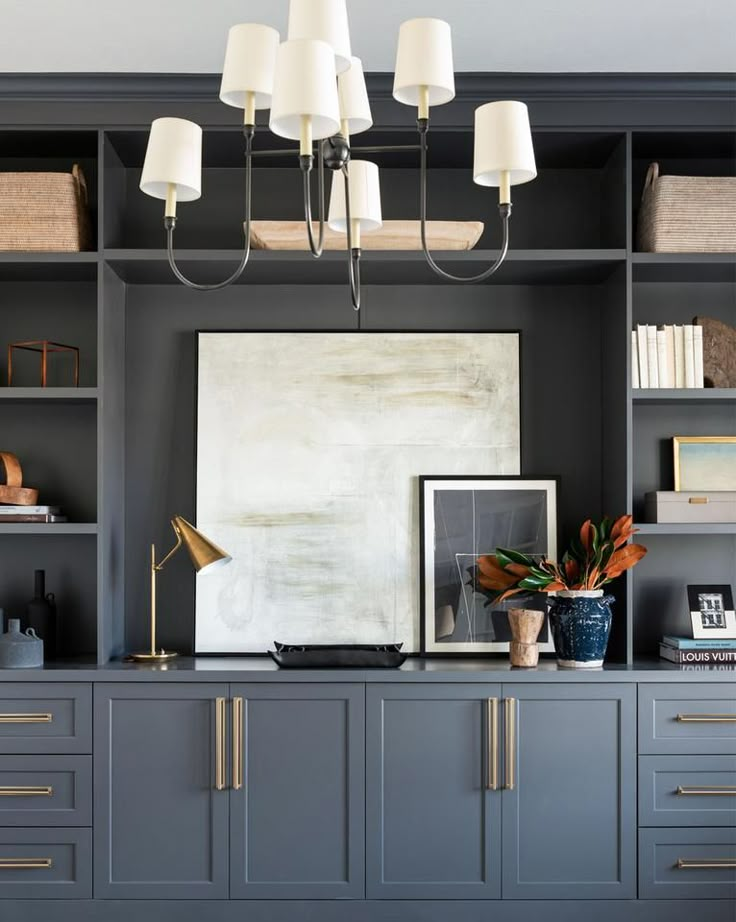 a living room with gray cabinets and white lamps