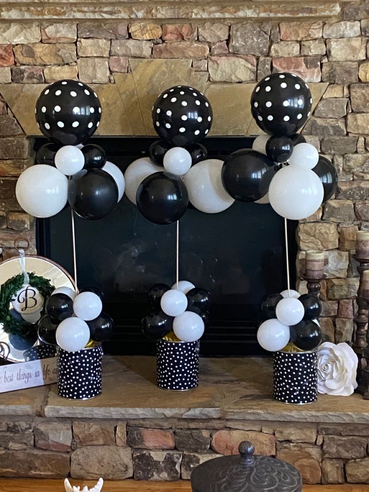 a fireplace decorated with black and white balloons