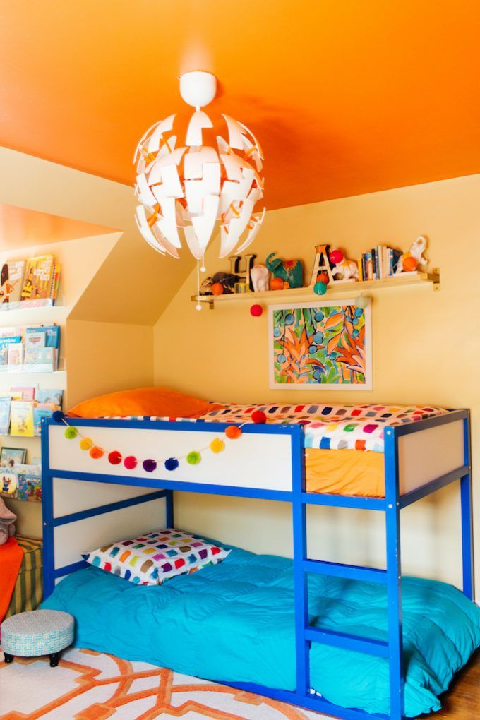 a bedroom with two bunk beds and a colorful rug on the floor in front of it