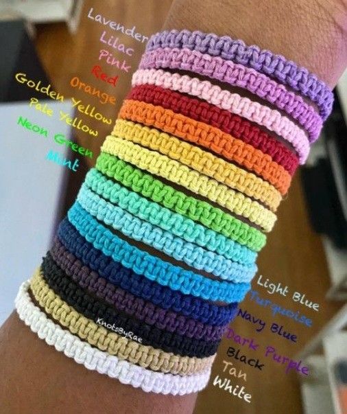 there are many different colors of bracelets on the arm, and each has an individual's name