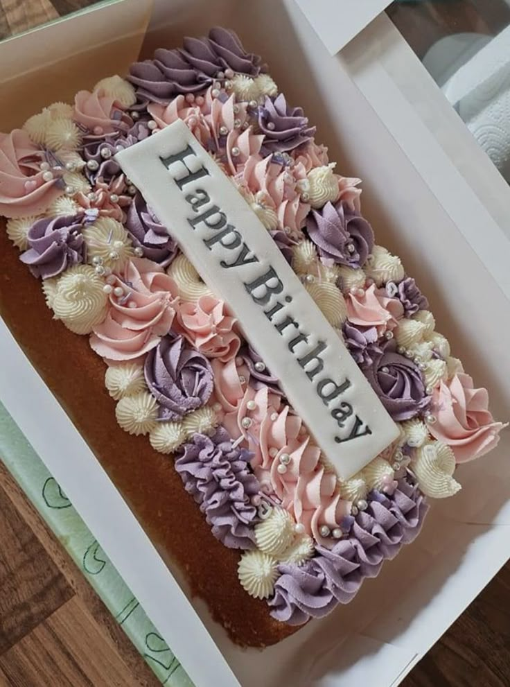 a birthday cake in a box on a wooden table with the words happy birthday written on it