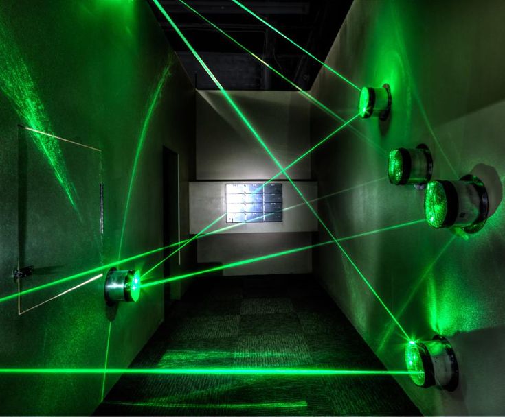 a hallway with green lasers on the walls