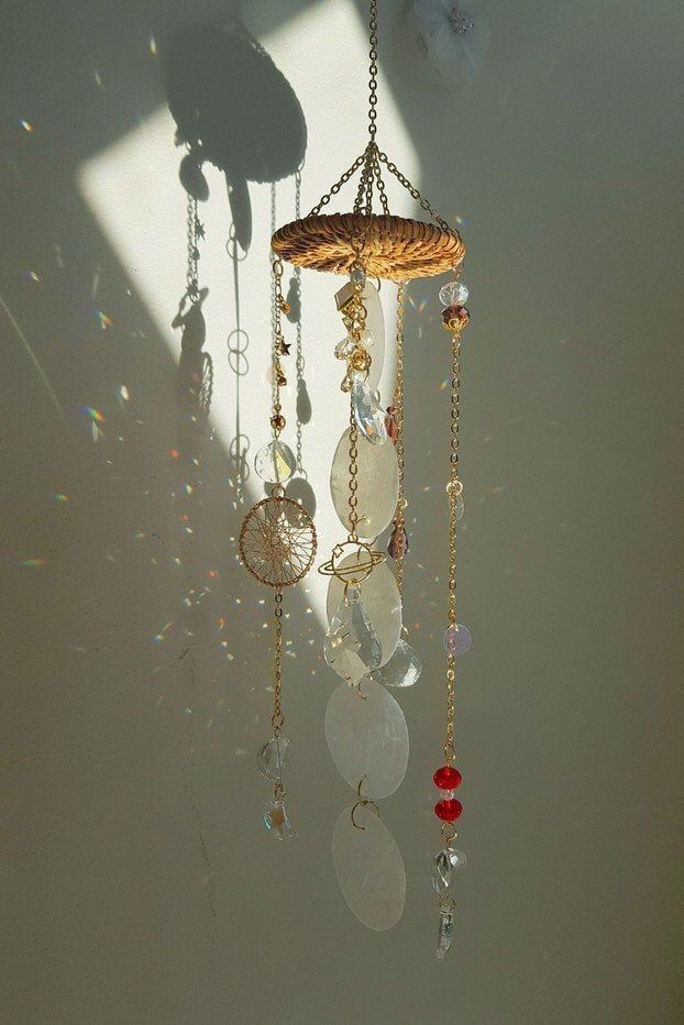 a wind chime hanging from the ceiling with beads and other items attached to it