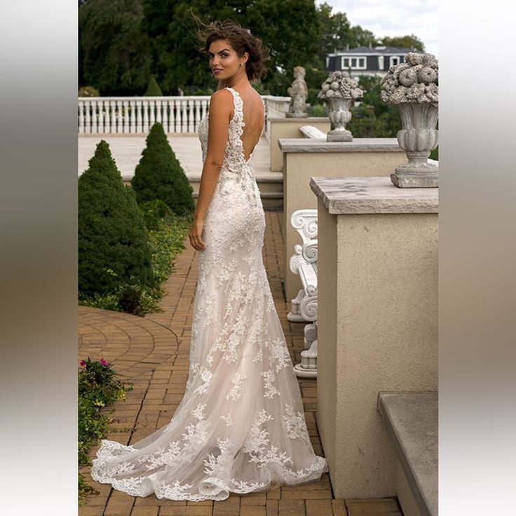 a woman in a wedding dress standing on a brick walkway