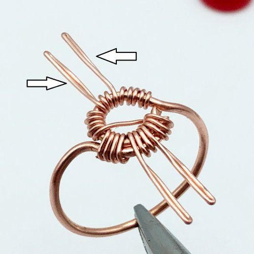 a pair of scissors are being used to make a wire wrapped ring with two loops