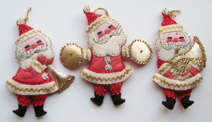 three christmas ornaments with santa clause on them