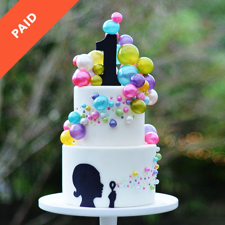 a three tiered cake with balloons on it