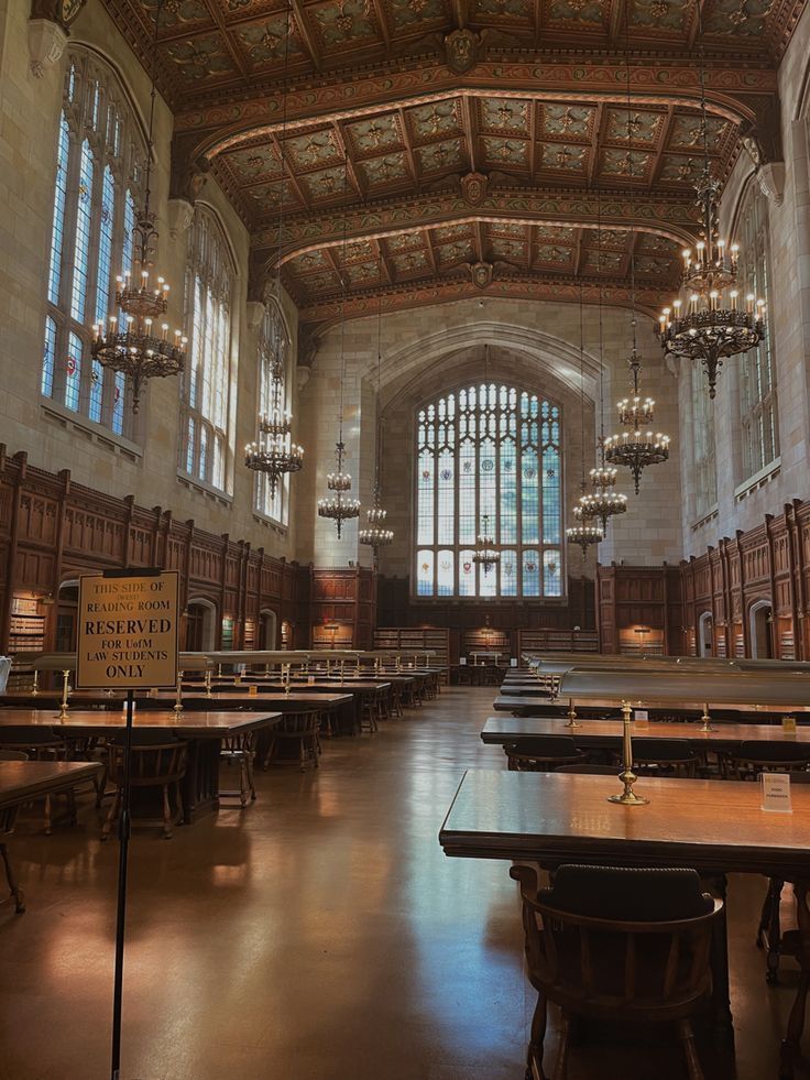 an old building with tables and chandeliers in the center, along with large windows