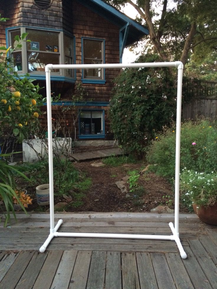 a white ironing board sitting on top of a wooden deck next to a house