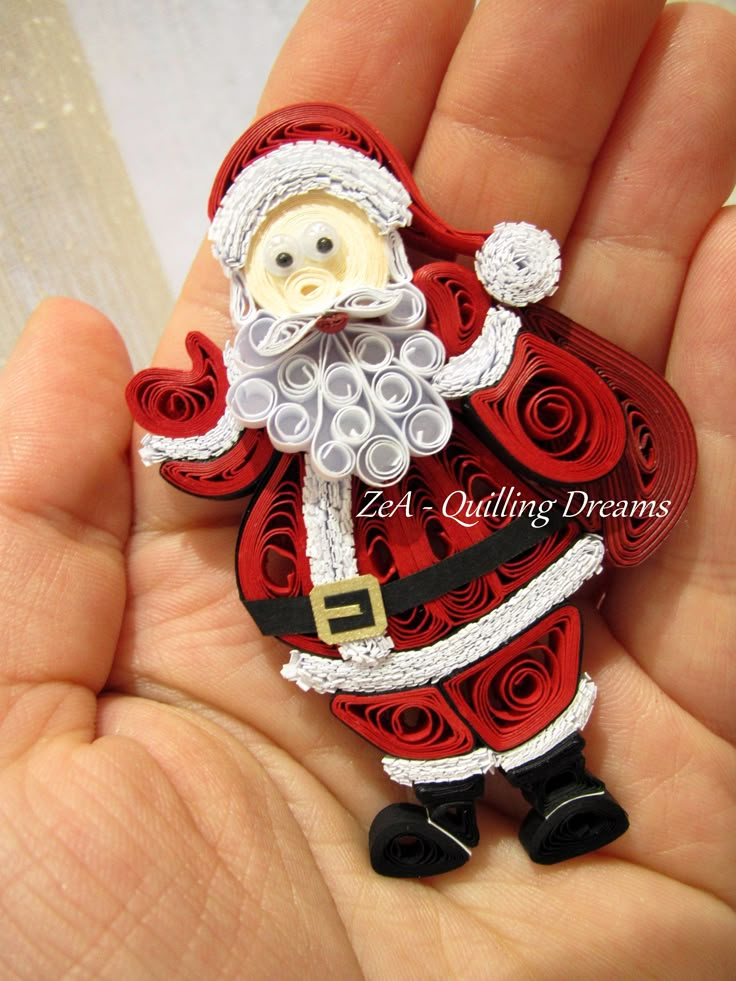 a hand holding a red and white santa clause ornament