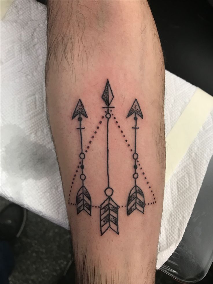 an arrow and arrows tattoo on the leg