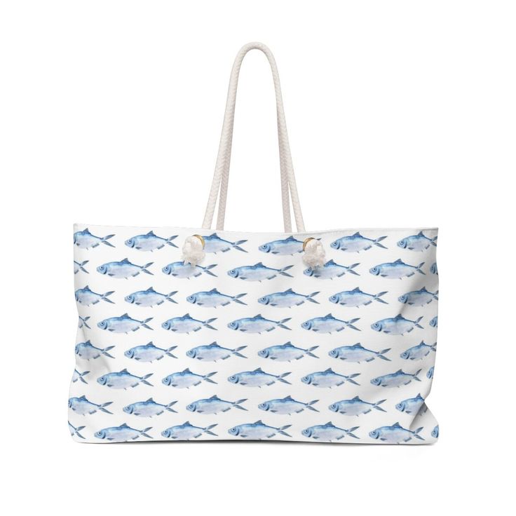 a blue and white bag with fish on the front, it has two handles that are attached