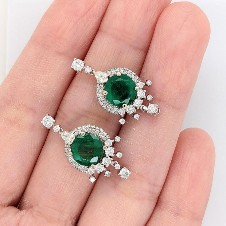 These beautiful earrings feature a pair of 3.57-carat weight round emerald gemstones with natural earth-mined diamonds, all set in solid 14K gold. These earrings can be a lovely May birthstone gift for your loved ones! These earrings are made with solid 14k Gold and natural earth-mined SI / G-H Diamonds. As listed, these earrings are ready to ship. If you're interested in purchasing this setting with a different center stone please message us! Luxury Round Emerald Diamond Earrings, Emerald Earrings With Halo Setting, Emerald Gemstone Earrings Round Cut, Round Emerald Earrings With Halo Setting, Elegant Round Emerald Earrings, Emerald Halo Setting Round Earrings, Elegant Round Cut Emerald Earrings, Elegant Round Cut Green Earrings, Green Round Earrings With Halo Setting