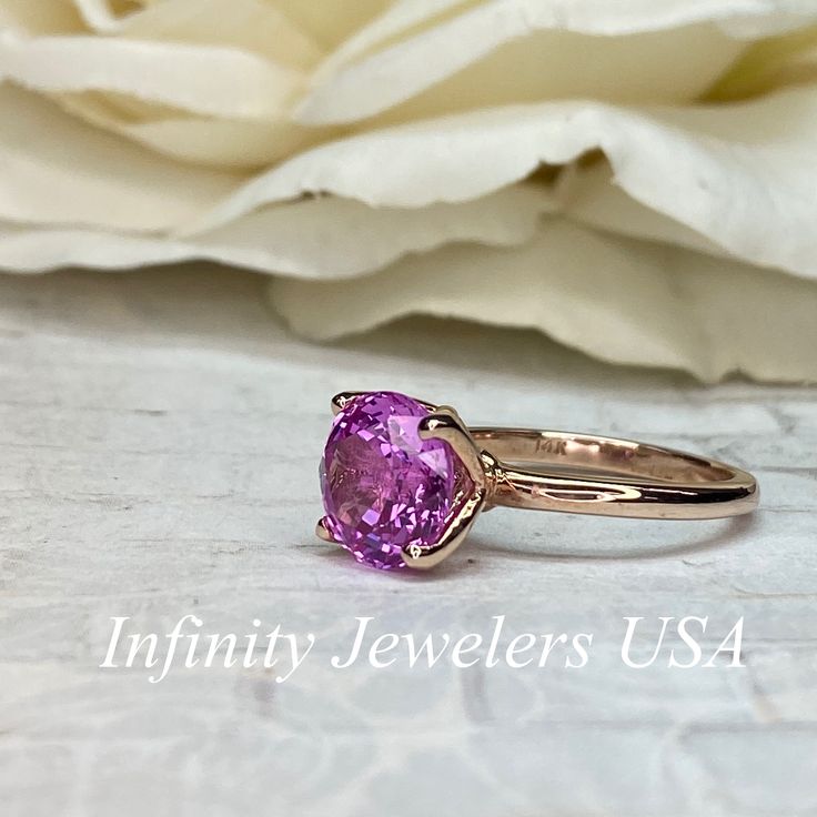 "This ring is a round cut lab created pink sapphire solitaire in 14k rose gold #6465 -Approximate total carat weight: 2.70ctw. diamond equivalent -Center Stone Size: approx. 2.70ct diamond equivalent -Center Stone Shape: round cut / 9 MM -Gem Type: lab created pink sapphire -Stone Clarity: VS2 -Stone Color: Medium Pink -Moh's Scale: 9 hardness -Metal Type and Purity: 14k rose gold -Setting: classic Tulip 4 Prong Setting -Stock Ring Size: 6 -Country of Manufacturing: USA (Michigan) For customizat Pink Round Cut Ruby Ring, Pink Brilliant Cut Ruby Ring For Gift, Pink Brilliant Cut Ruby Ring Gift, Fine Jewelry Pink Sapphire Ring, Pink Sapphire Round Cut Ring, Pink Gold Sapphire Ring With Gemstone, Pink Ruby Ring With Prong Setting, Pink Sapphire Jewelry With Center Stone, Pink Sapphire Ring With Round Cut For Anniversary