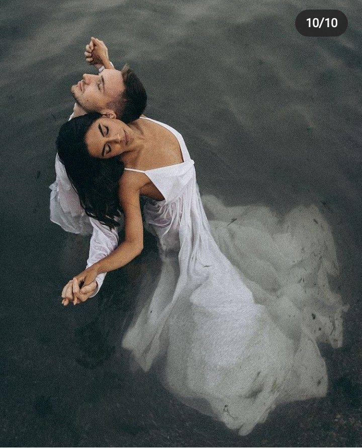 a man and woman are floating in the water with their arms around each other as if they were holding hands