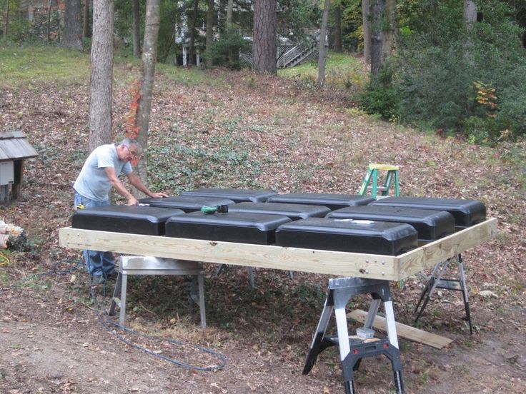 a man is working on some kind of thing in the woods with his hands together