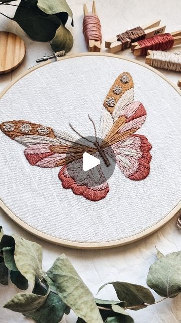 a close up of a embroidery on a table with scissors and other crafting supplies