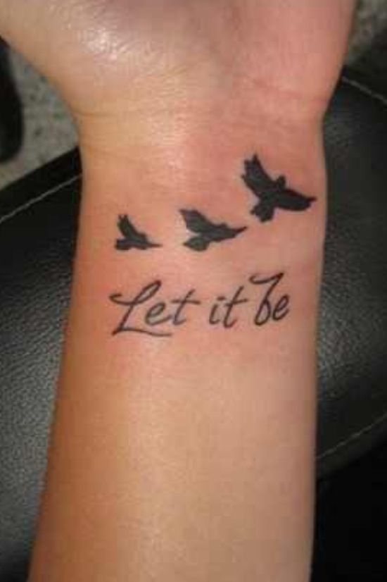 a wrist tattoo that says let it be with three birds flying in the sky above it