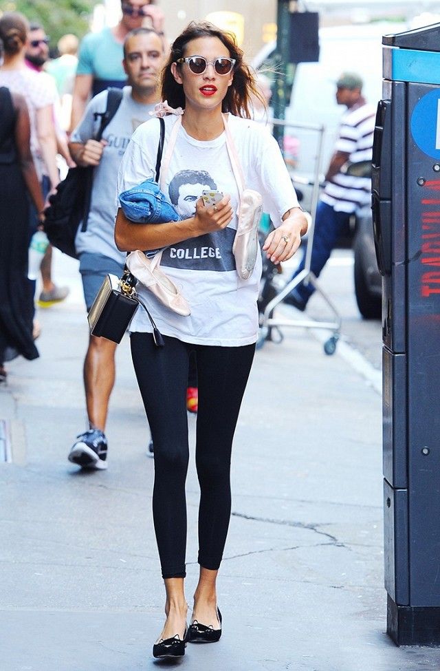 a woman walking down the street while wearing sunglasses