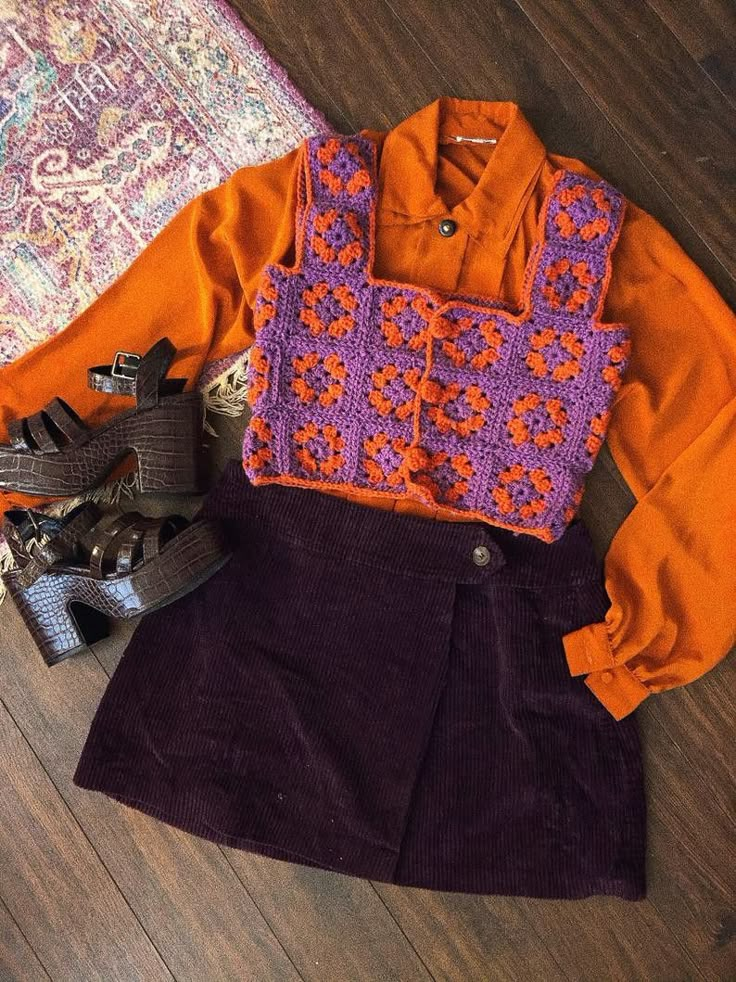 an orange shirt and purple skirt are sitting on the floor