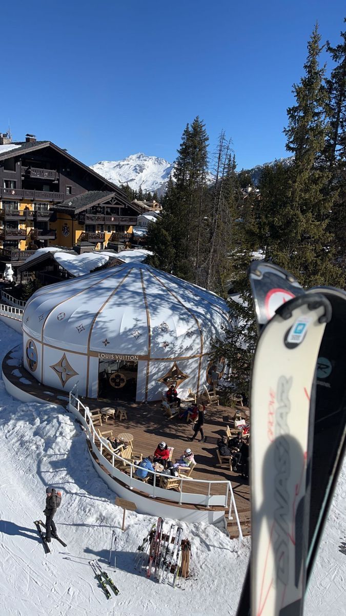 a snow covered ski lodge with skiers in the foreground