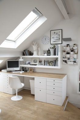 an attic bedroom with white furniture and open shelves on the wall, along with a skylight