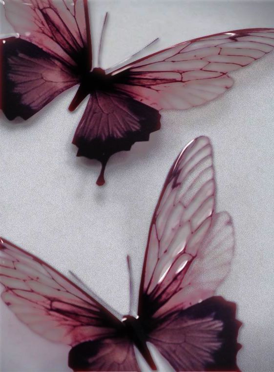 three purple butterflies sitting on top of a white countertop next to eachother